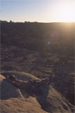 A figure seated on sunlit rock