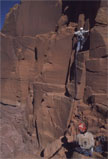Climbers on an orange sandstone face
